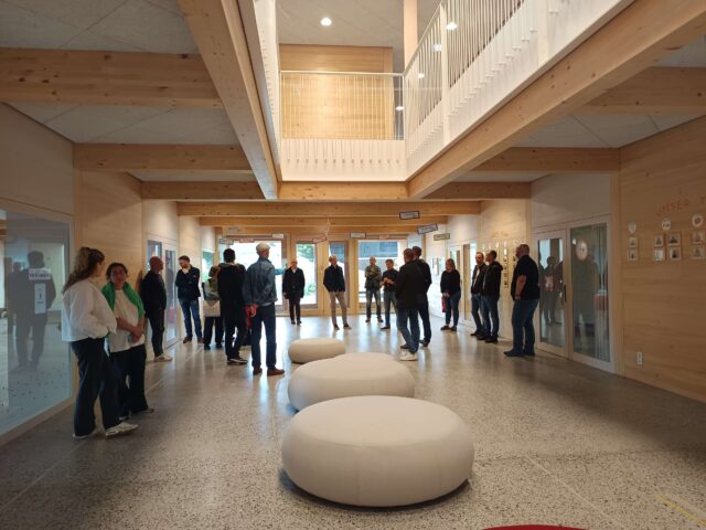 Die Teilnehmenden stehen in einem modernen Foyer