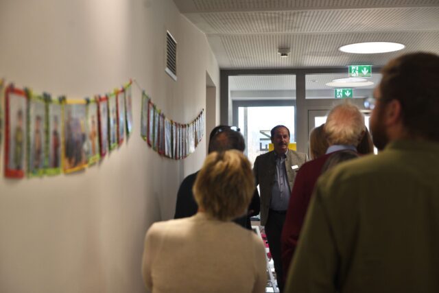 Bürgermeister Johann Gassner führt die Teilnehmer:innen des e5-ERFA-Treffens durch die neu sanierte Volksschule.