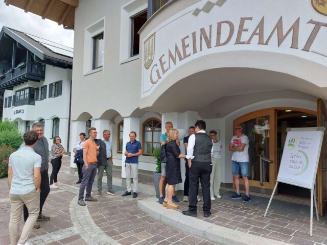Mehrere Menschen stehen vor dem Gemeindeamt in Wald im Pinzgau.