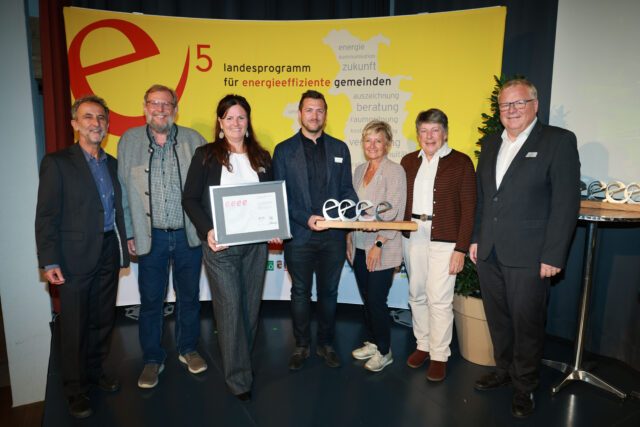 Energie-Gemeindetag in der Bachschmiede in Wals-Siezenheim. Vier „e“ für Bruck an der Großglocknerstraße. LAbg. Simon Wallner und Helmut Strasser (SIR) bei der Überreichung an Bgmin Barbara Huber und Vertreter:innen der Gemeinde. Foto: SIR/Franz Neumayr