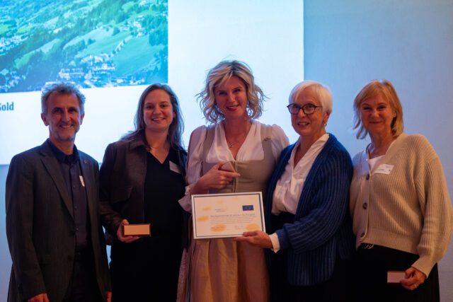 Vier Frauen und ein Mann halten Urkunden und Auszeichnungen in den Händen