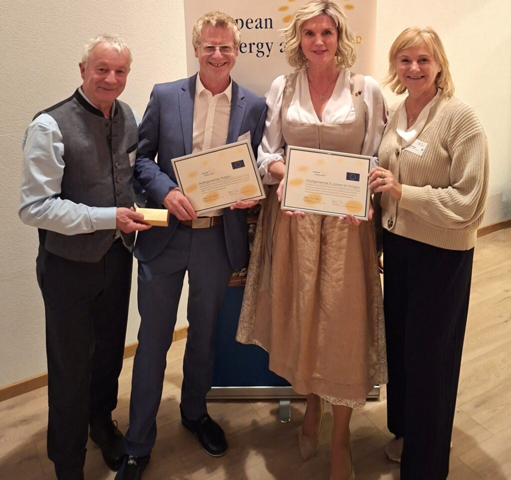 Zwei Männer und zwei Frauen halten Urkunden in der Hand.