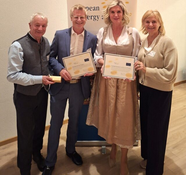 Zwei Männer und zwei Frauen halten Urkunden in der Hand.