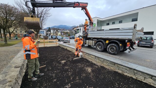 Ein Arbeiter und eine Arbeiterin bereiten eine Erdfläche vor.