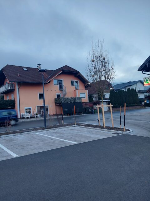 Ein Parkplatz mit freien Streifen, in denen Erde liegt.