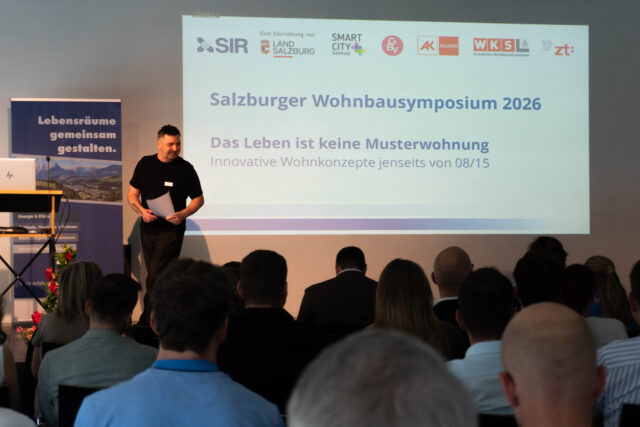 Moderator Wojciech Czaja steht auf der Bühne.