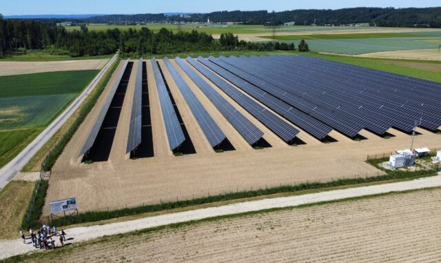 Ein großes Feld auf dem mehrere Reihen an Photovoltaikanlagen aufgestellt sind.