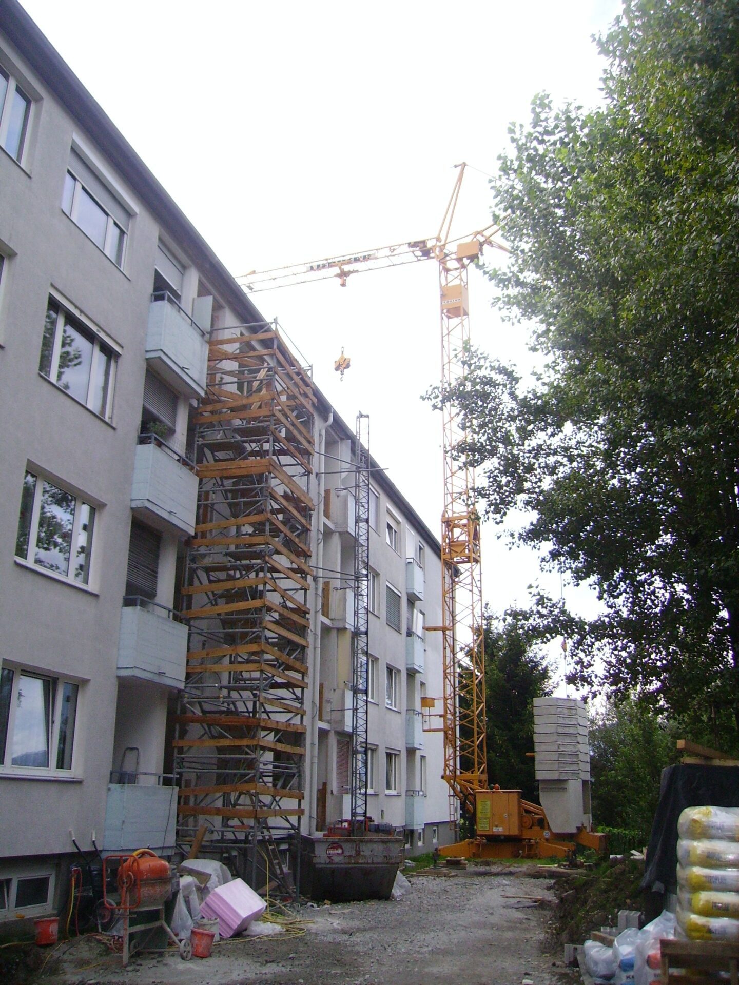 Ein Kran vor einem Wohnhaus, das saniert wird