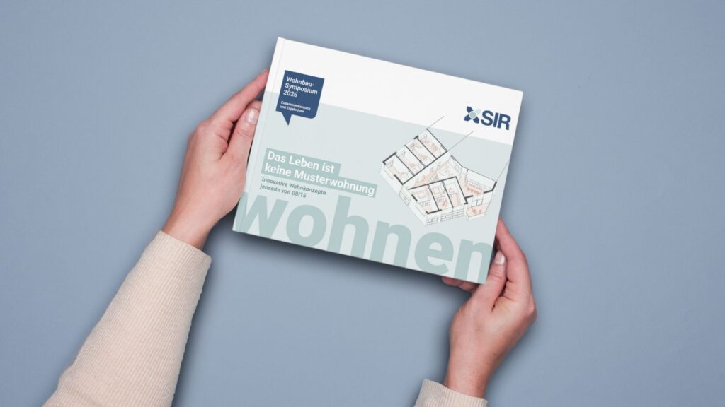 Zwei Hände halten die Nachlese zum Wohnbausymposium mit dem Titel: Das Leben ist keine Musterwohung – Innovative Wohnkonzepte jenseits von 08/15
