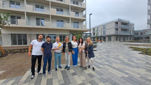 Sieben Personen stehen vor dem Quartier GNICE.