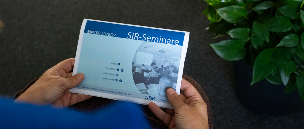 Zwei Hände halten das neue SIR-Seminarprogramm.